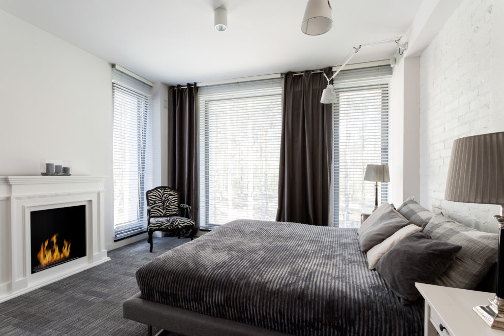 Grey bedroom with fireplace and bed