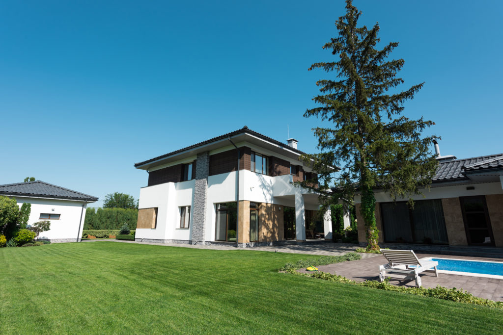 view of new modern house with swimming pool and green lawn